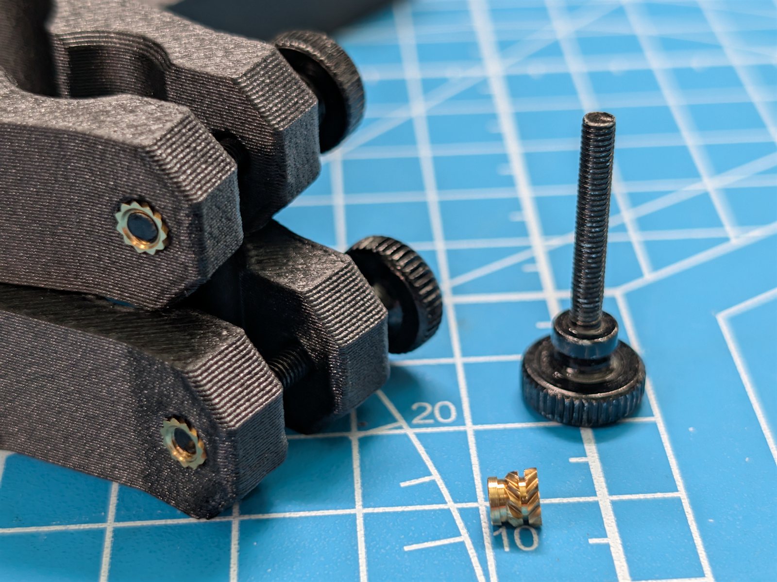 Close-up of a heat-set threaded insert installed in a printed part.